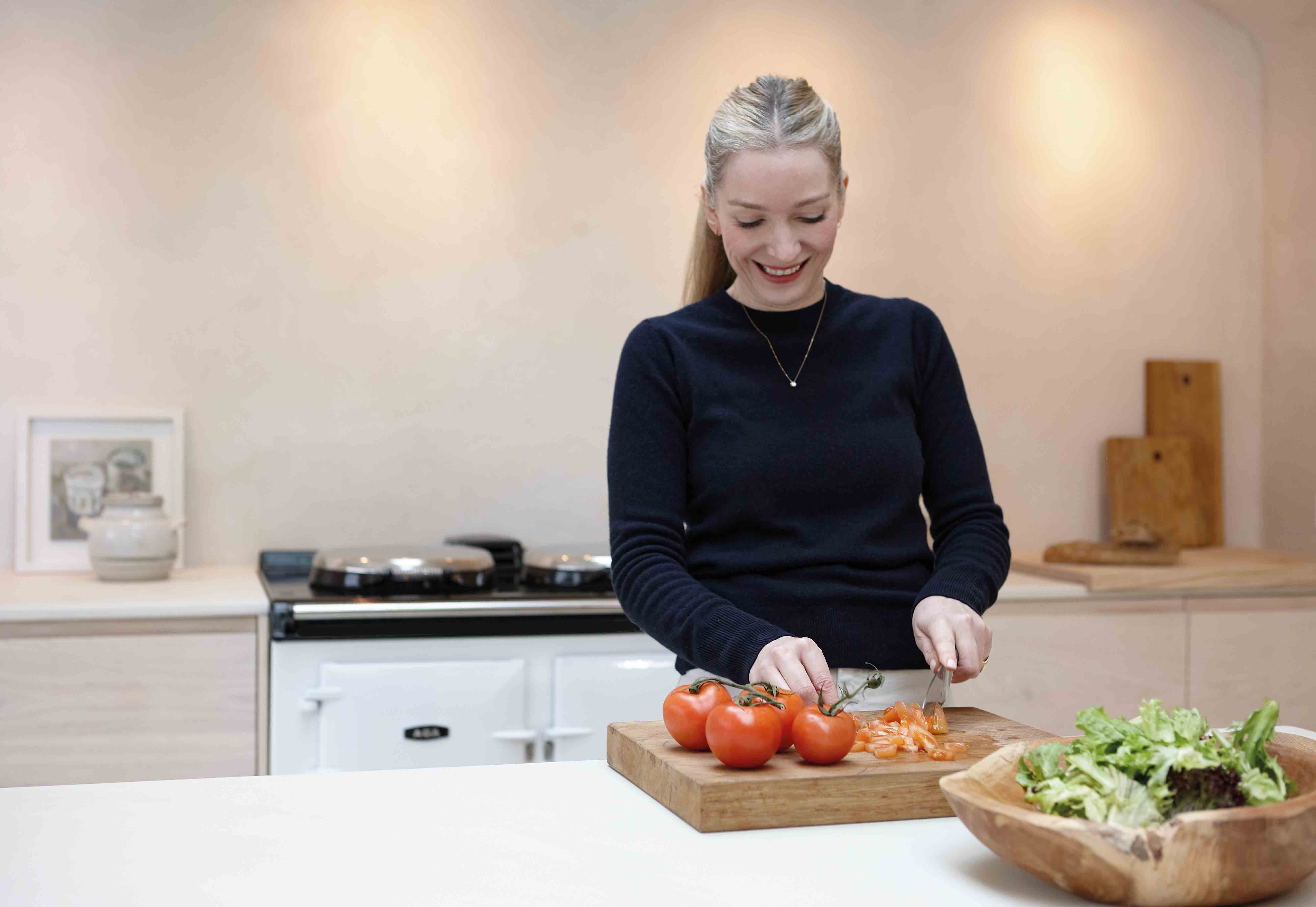Louisa Grey in cooking in kitchen in front of white AGA eR7