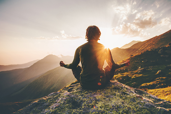 Man meditating in sunset