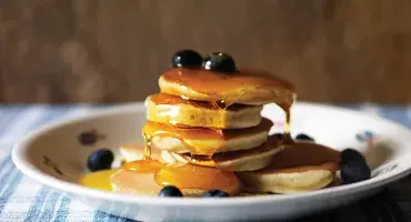 Drop Scones on a plate with blueberries and maple syrup