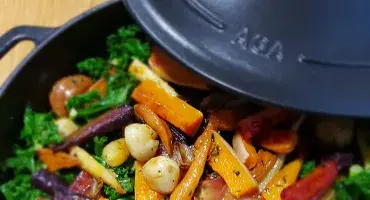 Colourful vegetables on a bed of steamed kale